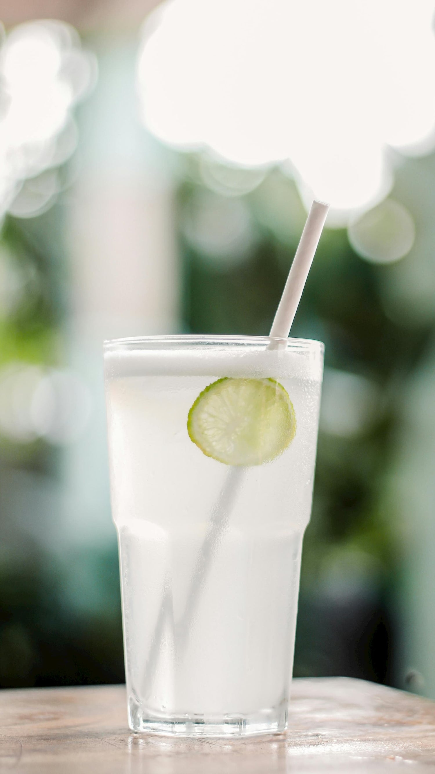 Paper straw in a fresh limeade glass on a table